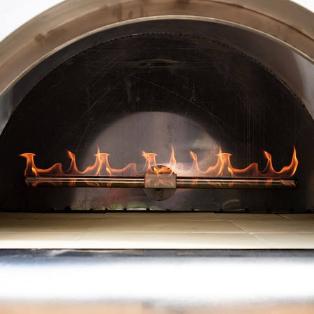 Inside view of a gas-fired oven, showing the cordierite cooking floor and the burner lit.