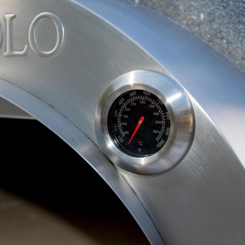 A close-up of the round temperature gauge on the Fire One Up PINNACOLO L’ARGILLA Gas Fired Outdoor Clay Pizza Oven (PPO-8-08) shows readings in Celsius and Fahrenheit, with the needle at about 400°C (750°F) and partially visible OLO engraving.