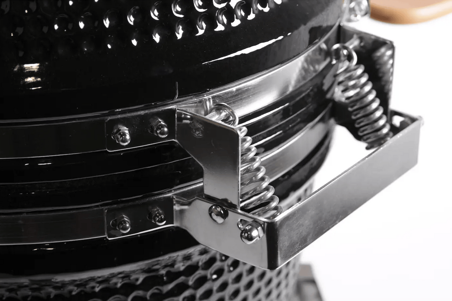 Close-up of the Kokomo Grills 21-Inch Kamado Ceramic BBQ Grill (KO-21-KAMADO) in black, featuring a textured surface and silver coiled-spring handle, set against a white background—ideal for charcoal cooking enthusiasts.
