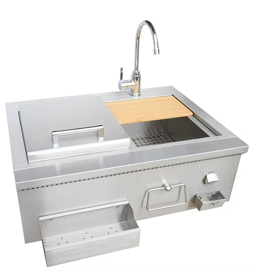 The Kokomo Grills 30” Built-In Bartender Cocktail Station features a stainless steel sink, bottle opener, ice chest, covered compartment, side shelf, control knob, and a wooden cutting board over part of the sink area.