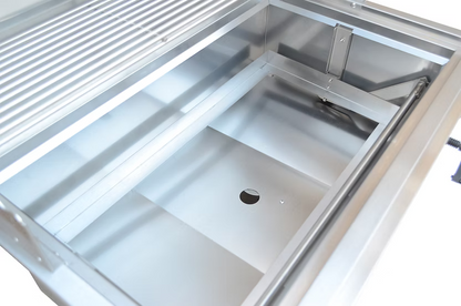 A close-up of the Kokomo Grills 32-Inch Built-In Charcoal Grill by Kokomo Grills, showing its empty stainless steel basin, drain hole, and smooth metal surfaces—an ideal choice for your outdoor kitchen setup.