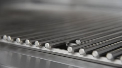 Close-up of metal rods with hexagonal ends aligned on a metallic surface, likely components for the Kokomo Grills 32-Inch Professional Built-In Gas Grill (4 Burner) by Kokomo Grills.