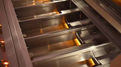 Close-up of an empty stainless steel oven rack in the Kokomo Grills 40-Inch Professional Built-In Gas Grill (5 Burner), with warm lighting reflecting off the metal for a clean, modern look—ideal for any outdoor kitchen.