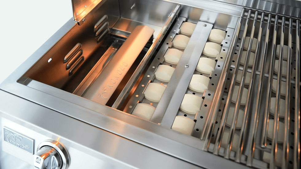 Close-up of the Kokomo Grills 40-Inch Professional Built-In Gas Grill (5 Burner) showing ceramic briquettes beneath a metal grate and a visible control knob—ideal for enhancing any outdoor kitchen setup.