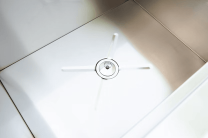 Close-up of a clean, modern stainless steel sink with a circular drain and four diagonal lines, echoing the sleek design of the Kokomo Grills Drop-In Stainless Steel Ice Chest 23 x 17 KO-AIC by Kokomo Grills.