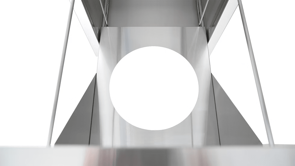 A geometric metal structure with a large circular cutout and minimalist, reflective surfaces, reminiscent of the Kokomo Grills Outdoor Kitchen Stainless Steel Dual Trash/Propane Pull-Out KO-TRHD-2 by Kokomo Grills.