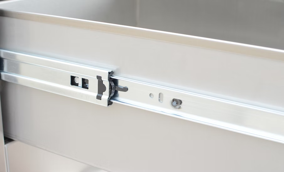 A close-up of the Kokomo Grills Outdoor Kitchen Stainless Steel Single Drawer KO-SD6 slide mechanism, highlighting the sliding rail and locking details attached to an outdoor kitchen drawer.
