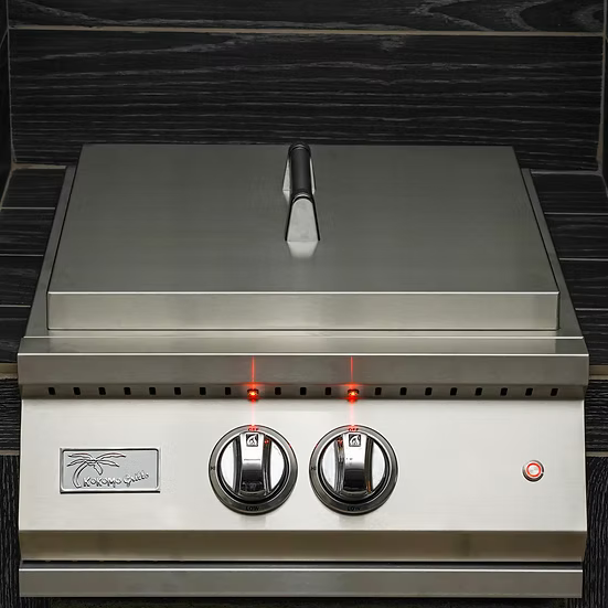 The Kokomo Grills Professional Built-In Power Burner features LED control knobs, a removable wok grate, and a stainless steel design—ideal for any outdoor kitchen. Shown with a closed lid against dark wood panels.