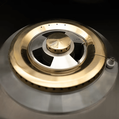 Close-up of the KoKoMo Grills Professional Double Side Burner with Removable Cover by Kokomo Grills, featuring stainless steel and brass accents, central cap, and circular gas outlets—ideal for any outdoor kitchen.