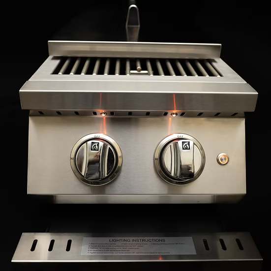 The KoKoMo Grills Professional Double Side Burner with Removable Cover by Kokomo Grills features two control knobs, indicator lights above each knob, a stainless steel grate, and a sleek black background—ideal for your outdoor kitchen.