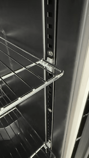 Close-up of metal wire shelves inside the Kokomo Grills Professional Luxury Outdoor Kitchen Kegerator KO-LUX-KEG, featuring adjustable supports and a dark interior—ideal for any outdoor kitchen setup.