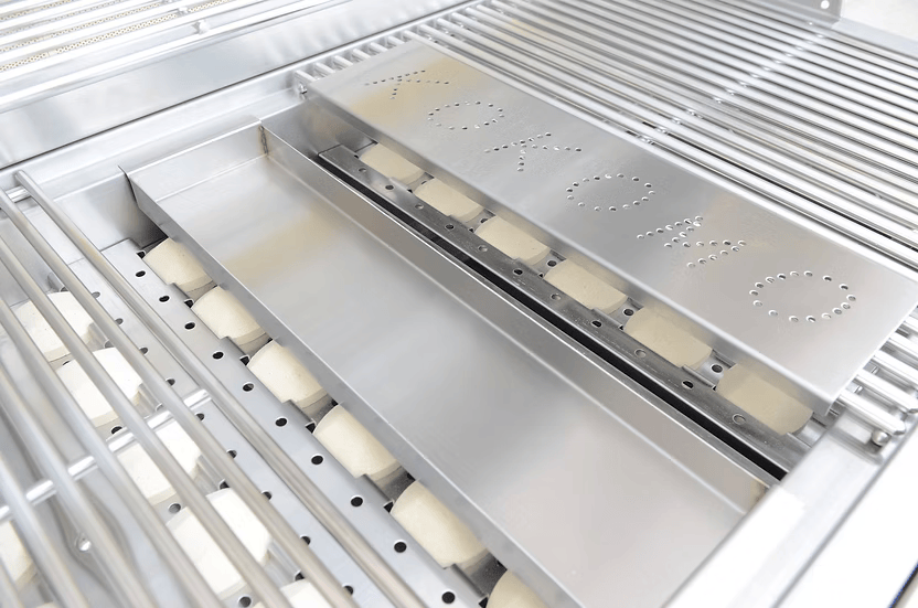 Close-up of a stainless steel grill with "Kokomo Grills" perforated on the cover, featuring grates, burner parts, and a Kokomo Grills Smoker Chip Box Insert KO-BAK-SMKBX—an essential BBQ accessory for smoky flavor.