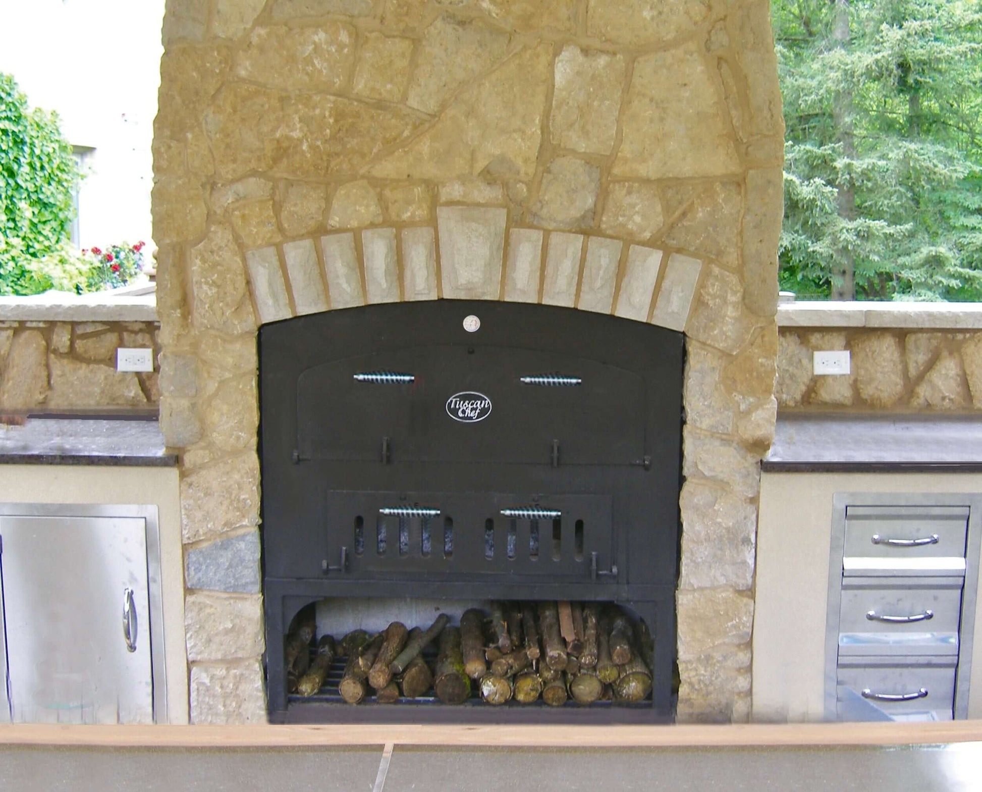 Tuscan Chef Large Built-In Pizza Oven (Model GX-DL) – Installed in a yellow brick enclosure within an outdoor kitchen setting.