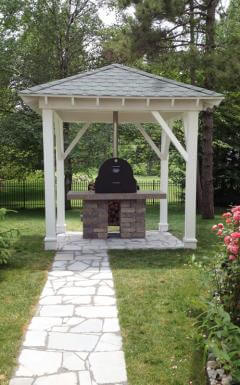 Tuscan Chef GX-B1 wood-fired oven set on a stone and granite platform with chimney vented through gazebo roof.