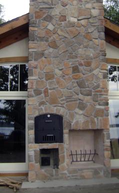 Uncommon installation of a wood-fired oven built into a wide stone pillar at the front of the house.