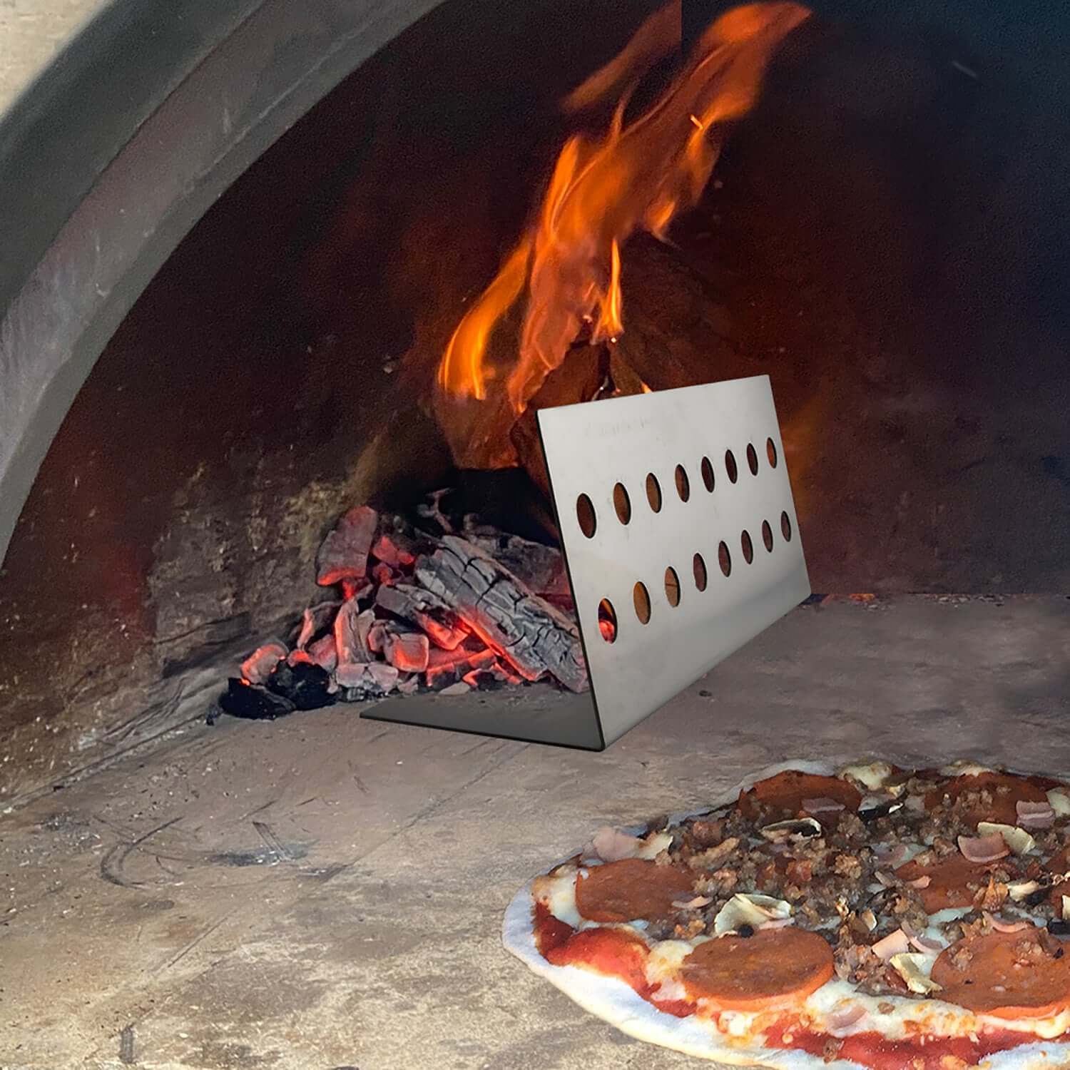 PINNACOLO Fire Separator – Burning wood and ash separated by the accessory on the left side of the cooking floor.