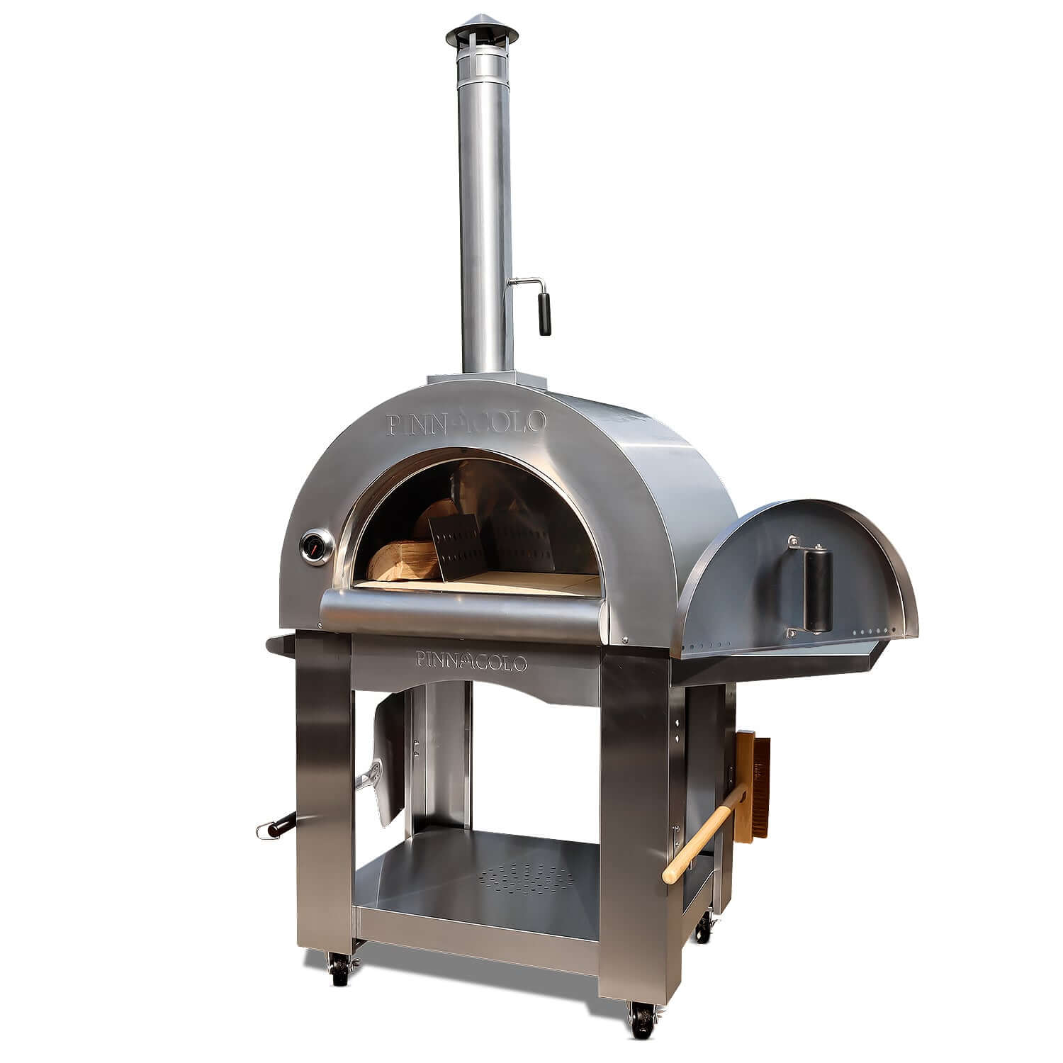Front-right view of the PINNACOLO PREMIO Wood-Fired Outdoor Pizza Oven, with a side shelf, brush and peel on the lower handles, and an open door revealing a log of wood and metal separator.