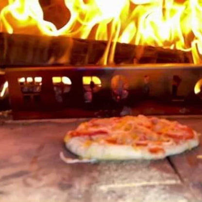 Pizza pie baking inside the Kokomo 32” Outdoor Wood-Fired Stainless Steel Pizza Oven, with flames visible in the background.